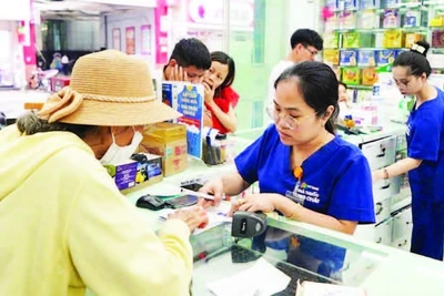 Người dân mua thuốc trên đường Hai Bà Trưng, phường Tân Định. (Ảnh THẾ ANH)