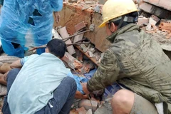 Các lực lượng chức năng đưa các nạn nhân ra khỏi đống đổ nát.