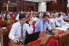 Các đại biểu Hội đồng nhân dân tỉnh Đắk Lắk biểu quyết thông qua nghị quyết.