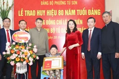 Đồng chí Nguyễn Thị Hương, Phó Bí thư Thường trực Tỉnh ủy Bắc Ninh trao Huy hiệu 80 năm tuổi Đảng tặng đảng viên Lê Thị Biên, chi bộ tổ dân phố Trần Phú, Đảng bộ phường Từ Sơn.