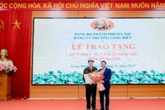 Bí thư Đảng ủy phường Long Biên trao Huy hiệu Đảng tặng đảng viên.