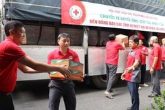 Cán bộ Hội Chữ thập đỏ Thành phố Hồ Chí Minh bốc xếp lương thực và nhu yếu phẩm lên xe ủng hộ đồng bào bị thiên tai, bão lũ tại thành phố Huế. 