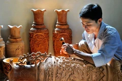 Người thợ chạm khắc gỗ tại làng nghề truyền thống Vân Hà (Hà Nội).