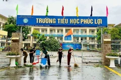 Các giáo viên, cán bộ, nhân viên Trường tiểu học Phúc Lợi dọn dẹp trường học sau đợt bão số 3 năm 2024.