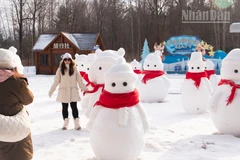 Du khách chụp ảnh check-in với người tuyết bên ngoài ga tàu cao tốc Trường Bạch Sơn.