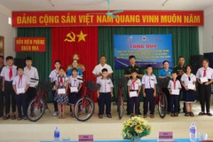 Đại diện Đồn Biên phòng Xuân Hòa phối hợp với Ủy ban Mặt trận Tổ quốc Việt Nam xã Xuân Cảnh trao quà cho các em học sinh.