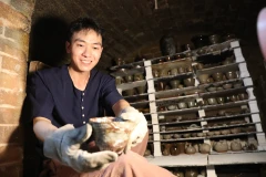 Niềm vui với thành quả sáng tạo như làm bừng sáng gương mặt của nghệ nhân gốm trẻ ở làng nghề truyền thống Phù Lãng, tỉnh Bắc Ninh. (Ảnh Minh Lê)