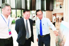 Các đại biểu tham quan triển lãm ảnh mô phỏng Trung tâm Tài chính quốc tế tại Thành phố Hồ Chí Minh. (Ảnh HOÀNG TRIỀU)