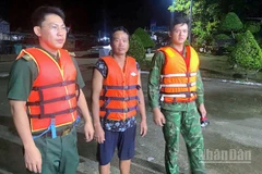 Cán bộ, chiến sĩ Đồn Biên phòng Khánh Hội cứu vớt ngư dân gặp nạn (giữa) đưa vào bờ an toàn.