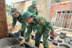 Thiếu tá Nguyễn Thanh Diễn cùng đồng đội trực tiếp xây tường, dựng lại mái ấm cho gia đình anh Trần Thế Lâm bị thiệt hại do mưa lũ.