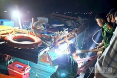 Cán bộ, chiến sĩ Đồn Biên phòng Hòn Chuối hỗ trợ đưa ông Đạt xuống tàu vào bờ tiếp tục cấp cứu, điều trị.