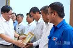 Chủ tịch Ủy ban nhân dân tỉnh Cà Mau Phạm Thành Ngại (bìa trái) tặng Bằng khen cho các cá nhân có nhiều đóng góp trong phong trào xóa nhà tạm, nhà dột nát.