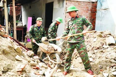 Cán bộ, chiến sĩ Trường Quân sự (Quân đoàn 34, tỉnh Gia Lai) hỗ trợ sửa chữa, xây dựng nhà cửa cho người dân sau bão lũ tại phường Ngô Mây.