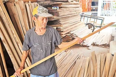 Ông Nguyễn Văn Nên kiểm tra độ trơn láng của các cây dầm. 