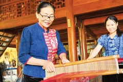 Nghệ nhân Sầm Thị Bích ( người bên trái) trình diễn kỹ thuật dệt thổ cẩm. (Ảnh THÀNH CƯỜNG)