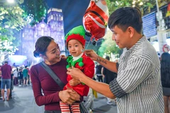 Gia đình đưa trẻ nhỏ đi đón Noel tại Nhà thờ Lớn.