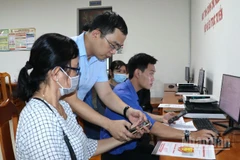 Lãnh đạo xã Long Thành hướng dẫn người dân nộp hồ sơ trực tuyến tại Trung tâm Phục vụ hành chính công.