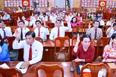 Các đại biểu Hội đồng nhân dân tỉnh Đồng Nai biểu quyết thông qua nghị quyết tại kỳ họp.