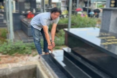 Đối tượng T.M.N tại ngôi mộ ông Phạm Hữu Tiến sau khi được gia đình sửa chữa lại.