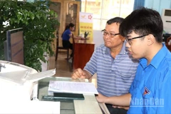 Ông Nguyễn Minh Trí được tình nguyện viên Tỉnh đoàn Đồng Nai hỗ trợ nộp hồ sơ trực tuyến.