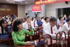 Các đại biểu Hội đồng nhân dân tỉnh Đồng Nai biểu quyết thông qua Nghị quyết tại kỳ họp.