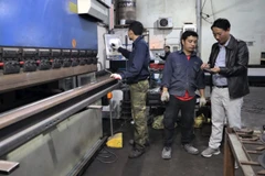 Anh Lê Lương Nguyên (ngoài cùng bên phải) trao đổi với lao động trong xưởng.