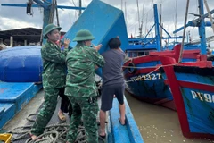 Cán bộ, chiến sĩ Đồn Biên phòng Xuân Hòa, Ban Chỉ huy Bộ đội Biên phòng tỉnh Đắk Lắk hỗ trợ ngư dân đưa phương tiện đánh bắt cá lên bờ, bảo đảm an toàn trước khi bão số 13 đổ bộ.