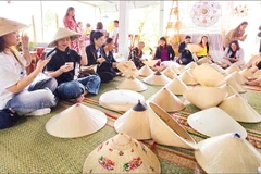 Du khách tham quan, tìm hiểu nghề làm nón ngựa Phú Gia.