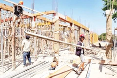 Các công nhân nỗ lực “vượt nắng thắng mưa” trên công trường xây dựng Trường phổ thông nội trú liên cấp tiểu học và trung học cơ sở xã Ia Lốp.