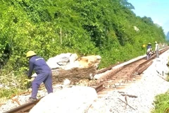Công nhân cắt xẻ tảng đá và sửa đường để thông tuyến đường sắt bắc-nam đoạn qua xã Tuyên Hóa, tỉnh Quảng Trị.