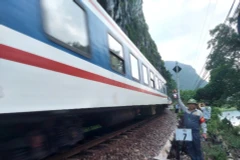 Nhân viên tuần hầm hướng dẫn tàu qua an toàn trên đoạn đường sắt xung yếu bên sông, bên núi đá ở huyện Tuyên Hóa, tỉnh Quảng Bình.