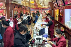 Người dân giao dịch mua vàng tại một cửa hàng trên phố Trần Nhân Tông (Hà Nội). (Ảnh: MINH PHƯƠNG)