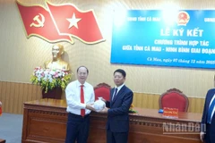 Bí thư Tỉnh ủy Cà Mau Nguyễn Hồ Hải (bìa trái) tặng quà lưu niệm cho đại diện tỉnh Ninh Bình tại lễ ký kết.