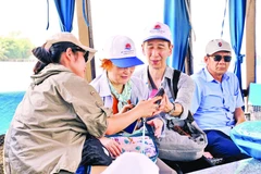 Bạn trẻ hướng dẫn vợ chồng du khách Nhật tham quan miền Tây. Ảnh: Nguyệt Anh