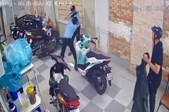 Hai bảo vệ (áo xanh) đánh nhau ở bãi giữ xe của quán hải sản. 