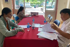 Lãnh đạo Ủy ban nhân dân phường Tân An hướng dẫn giải quyết thủ tục hành chính cho người dân sáng 1/7.