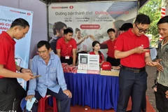 Người dân đến gian hàng của ngân hàng tham gia phiên chợ không dùng tiền mặt mở tài khoản thanh toán.