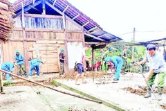 Cán bộ xã Nghĩa Tá ra quân giúp người dân thôn Bản Pèo xóa nhà tạm. (Ảnh DUY THÁI)