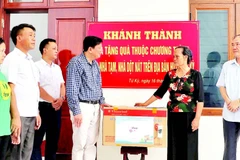 Đại diện chính quyền địa phương tặng quà gia đình bà Phạm Thị Thoa (ở xã Lạc Phượng) được hỗ trợ xây nhà mới.