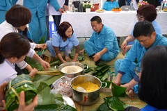 Các bác sĩ cùng người điều trị tham gia gói bánh chưng, chia sẻ không khí ngày Tết.