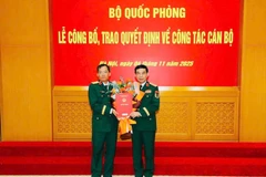 Thừa ủy quyền của Chủ tịch nước, thay mặt Quân ủy Trung ương, Bộ Quốc phòng, Đại tướng Phan Văn Giang trao Quyết định, tặng hoa chúc mừng Thiếu tướng Lương Đình Chung. (Ảnh: Quân khu 5 cung cấp)