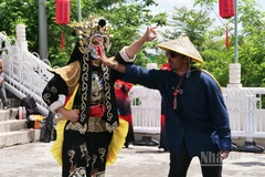 Du khách nước ngoài tương tác trực tiếp với diễn viên biểu diễn nghệ thuật biến mặt trên trường thành Mục Điền Dục.