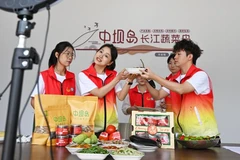 Sinh viên tình nguyện của Học viện Tài chính-Kinh tế Trùng Khánh, Trung Quốc live stream giới thiệu sản phẩm địa phương. (Ảnh: Tân Hoa Xã)