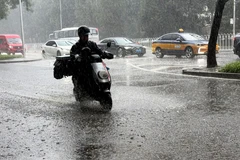 Một người đi xe đạp điện trong mưa ở quận Tây Thành, thành phố Bắc Kinh, Trung Quốc ngày 4/8. (Ảnh: Tân Hoa xã)