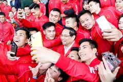 Thủ tướng Phạm Minh Chính trong trang phục thi đấu của Đoàn Thể thao Việt Nam tham dự SEA Games 33 chụp hình lưu niệm với các vận động viên.