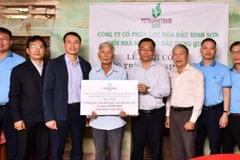 Đại diện Công ty cổ phần Lọc hóa dầu Bình Sơn trao số tiền 60 triệu đồng hỗ trợ gia đình ông Huỳnh Kiễn sửa nhà.