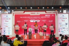 Bà Lê Thị Hoàng Yến, Phó Cục trưởng Cục TDTT và ông Phạm Xuân Tài, Phó Giám đốc Sở Văn hóa và Thể thao Thành phố Hà Nội trao giải cho các VĐV xuất sắc đường đua marathon nam.