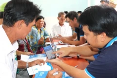 Nhân viên Xí nghiệp cấp nước Cần Giờ hướng dẫn và cài app SAWACO Chăm sóc khách hàng cho các hộ dân ở doi Mỹ Khánh.