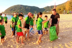 Du khách và các em nhỏ tích cực thu gom rác thải tại Vịnh Hạ Long. (Nguồn: CLB Vì một Hạ Long xanh)