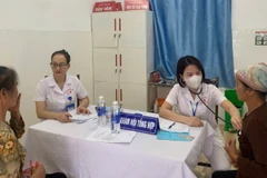 Các y, bác sĩ Trạm Y tế xã Xuân Mai đang thăm khám cho người dân vùng ngập úng. 